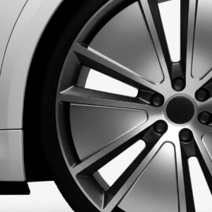 Close-up of a modern alloy wheel with a sleek, metallic finish on a white vehicle.