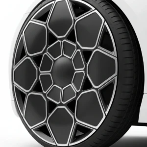 Stylish geometric alloy wheel design on a white car, showcasing intricate black and silver pattern.