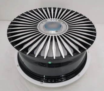 Close-up of a sleek black and silver automotive wheel rim with an intricate design and shiny finish.