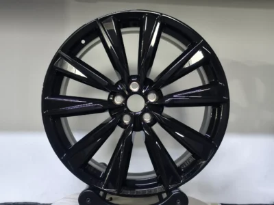 Glossy black alloy wheel showcasing a modern, stylish design, perfect for enhancing vehicle aesthetics.