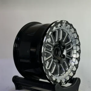 Stylish black and silver car wheel showcased on a stand, highlighting its intricate design and modern finish.