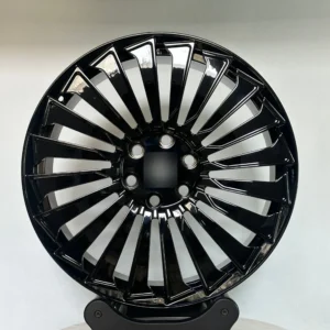 Shiny black alloy wheel with a modern design, showcasing sleek spokes and circular hub, perfect for enhancing vehicle aesthetics.