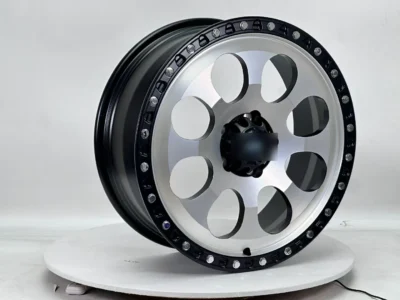 Shiny aluminum alloy wheel with black accents, designed for performance vehicles, displayed on a rotating stand.