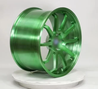 Shiny green alloy wheel on a display platform, showcasing a sleek design and modern craftsmanship. Perfect for custom vehicles.