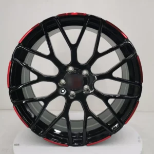 Sleek black alloy wheel with red accents, showcasing a modern design and detailed craftsmanship for automotive enthusiasts.