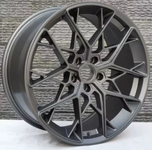 Modern alloy wheel with intricate design and sleek gray finish, perfect for enhancing vehicle aesthetics.