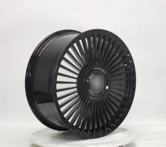 Glossy black alloy wheel with a unique spoke design, perfect for enhancing vehicle aesthetics and performance.