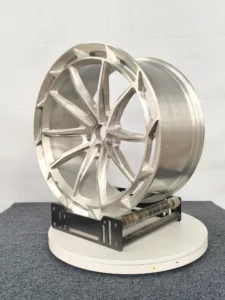 Stylish aluminum alloy wheel displayed on a rotating stand, showcasing its sleek design and polished finish.