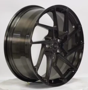 High-performance black alloy wheel displayed at an angle, showcasing a sleek design and modern styling features.