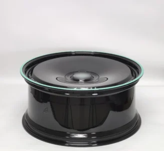 Glossy black custom wheel with a mint green rim detail, showcasing a sleek design for automotive enthusiasts.