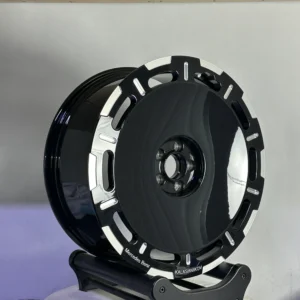 Glossy black Mercedes Benz wheel with silver detail, displayed on a stand against a neutral background.